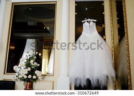 Beautiful white wedding dress for bride indoors. Beauty of bridal gown for marriage. Female lace clothes for celebration