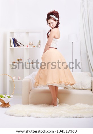 portrait of young beautiful retro woman in skirt with petticoat and corset posing in vintage interior