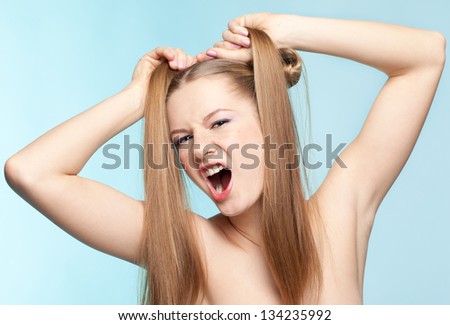 Beautiful crazy aggressive freckled girl on blue background