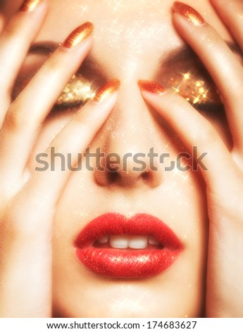 Soft focus portrait of beautiful young woman with shining face makeup and hands on face