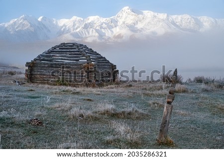 View on shepherd's house ail and Altai lake Dzhangyskol on mountain plateau Eshtykel. North Chui ridge is on background. Morning fog over water. Altai, Siberia, Russia Imagine de stoc © 
