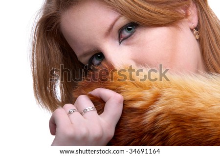 portrait of beautiful redhead pale skinned model hiding her face in fox fur scarf
