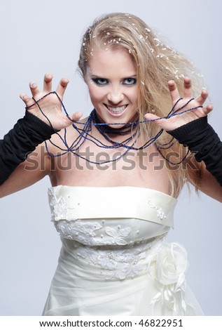 cold-tone portrait of playful blonde girl with snow in her hair posing jokingly agressive