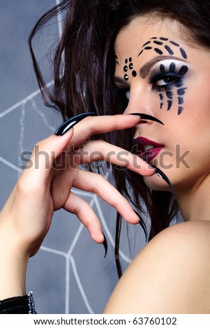 portrait of girl with spider bodyart of face zone looking over her shoulder