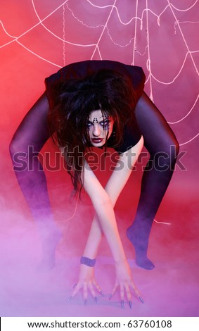 portrait of girl with spider bodyart of face zone posing around the web in violet light