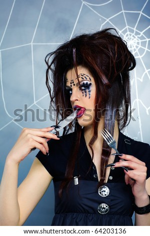portrait of girl with spider bodyart of face zone with knife and fork