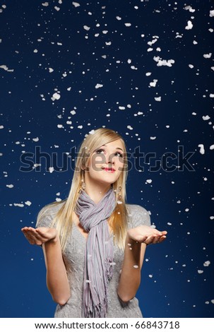 portrait of beautiful blonde girl happy with snowflakes falling down