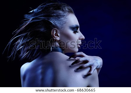 cold-tint portrait of beautiful girl with bird of prey make-up, hair-do and manicure