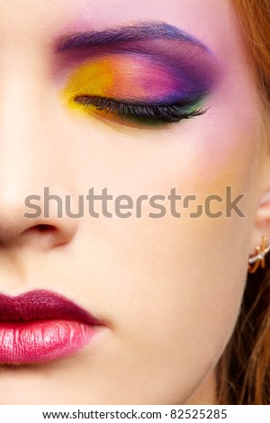 close up half face portrait of beautiful woman with colorful make-up with eyes shut
