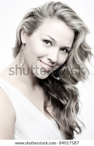 portrait of beautiful plus size curly young blond woman posing on gray