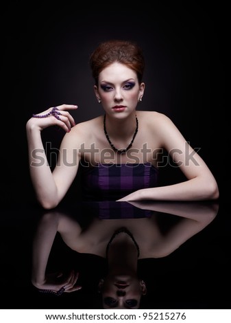 portrait of beautiful young woman at dark mirror table
