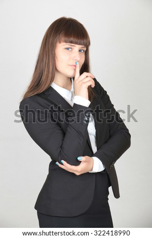 The girl in the office clothes. The black jacket and skirt, white blouse. Finger to her lips.