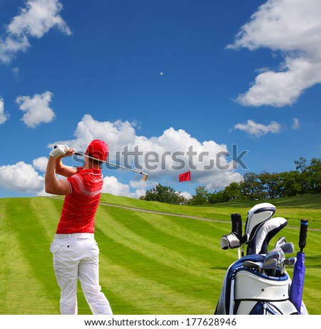 Man playing golf against blue sky with golf bag