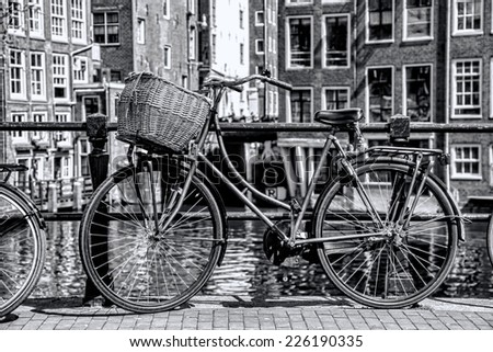 Amsterdam with old bicycle on the bridge against canal, Holland