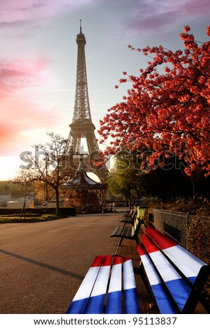 Eiffel Tower with french flag on bench during a spring time in Paris, France