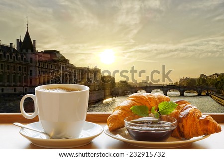 Paris coffee with croissants against sunset over city in France