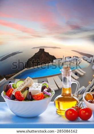 Greek salad against sunset on Santorini island in Greece