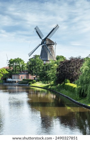 Similar – Image, Stock Photo Windmill at the lower edge of the picture in silhouette form and sky with contrails