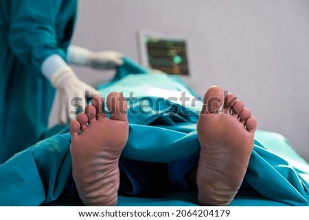 Selective focus at feet of pass away patient while doctor covering face inside of the surgery operation room in the hospital. Illness and death concept.  Foto stock © 