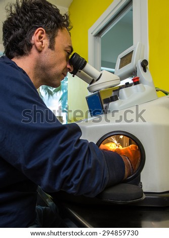 operator man working on a laser equipment for the production of dental prostheses