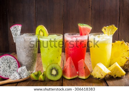 Fruit smoothies with dragon fruit, kiwi, watermelon, Pineapple on wooden table.