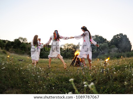 young girls in white shirts and wreaths of flowers on the background of a fire. The celebration of the pagan Slavic holiday of Ivan Kupala Day or Midsummer. ストックフォト © 