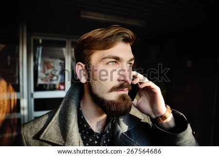 stylish man with a beard talking on cell phone
