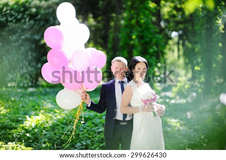 the bride and groom with a bunch of balloons
