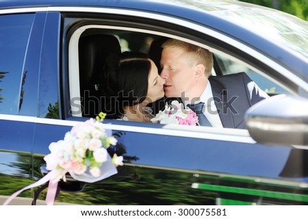 bride and groom kissing in wedding car