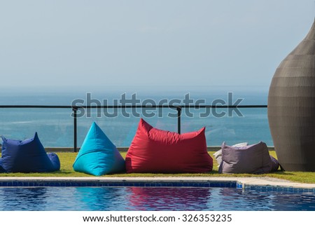 Colourful image of pool furniture in a tropical resort by the sea.