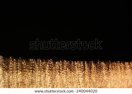 digitally generated image of gold light and stripes moving fast over black background