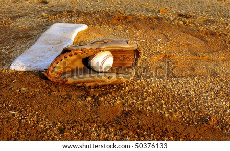 Baseball and glove on pitcher\'s mound