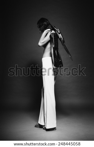 Glamour diver fashion model (girl, woman, female, lady) with long legs and perfect skin holding professional fins posing topless in studio for haute couture vogue black and white stylish photo shoot