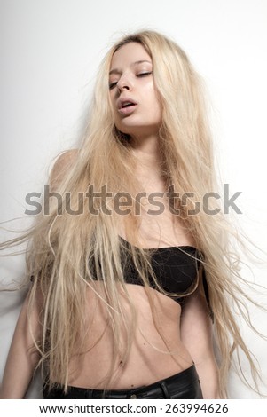 Young European attractive sexy fashion model with long blond natural hair, beautiful eyes, full lips, perfect skin is posing in studio for glamour vogue test photo shoot on white background