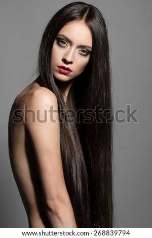 Awesome caucasian attractive sexy fashion model with long brunette natural hair, beautiful eyes, full lips, perfect skin posing topless in studio for beauty photo shoot, retouched image