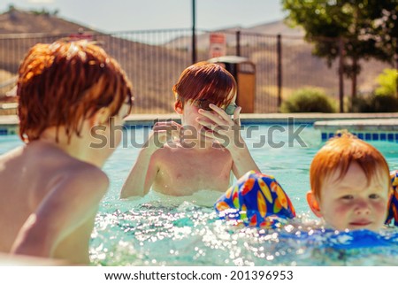 7, 4 and 2 year old brothers swimming in the pool together -- image taken in Reno, Nevada, USA