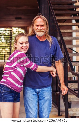 Tween girl hugging her grandfather -- image taken outdoors in Reno, Nevada, USA