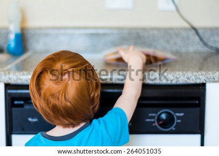 Young boy reaching for a snickerdoodle cookie in his kitchen. Photo taken in a home in Reno, Nevada, USA using natural window light.