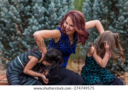 Mother playing with her young daughters outside at a park in Reno, Nevada, USA.