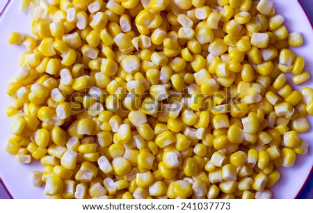 Canned corn grains on plate, close-up shut.
