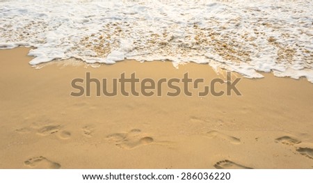 Sea wave and many foot print  on the beach background