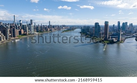 A high angle, aerial view of Manhattan from over the East River in NY. Taken on a sunny morning with clear blue skies and white clouds. 商業照片 © 
