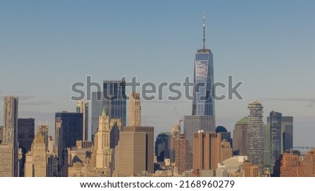 A high angle, aerial view of Lower Manhattan from over the East River in NY. Taken on a sunny morning with clear blue skies and white clouds. 商業照片 © 