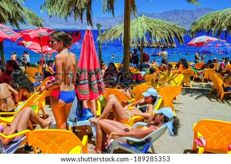 Eilat, ISRAEL - AUGUST 12: Holiday makers sun-bathing during high season on a sand beach in resort town of Eilat on Red Sea. Eilat, Israel, on August 12, 2012