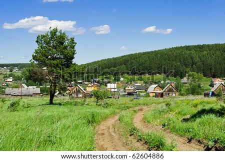 Summer landscape with a country road going to the Russian village