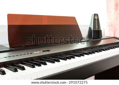 Closeup piano keyboard with metronome background. Abstract and art background.