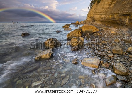 Rainbow over the cliff after passing an evening storm