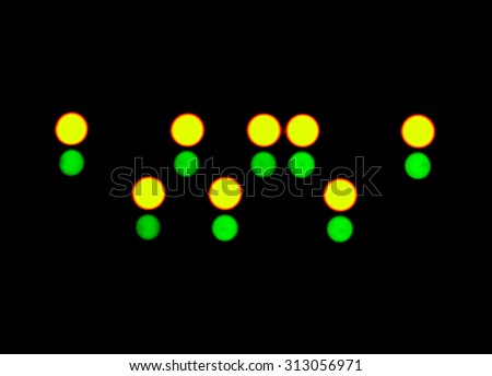 abstract blurred green and yellow LED flashing circles on a black background