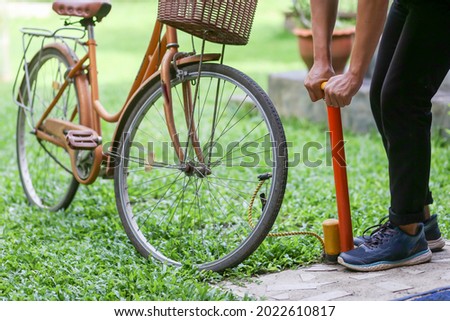Similar – Image, Stock Photo Woman inflating bicycle tire in workshop