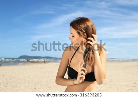 natural girl on a lonely beach brushes her healthy long hair. relaxation peace of mind and natural beauty concept
